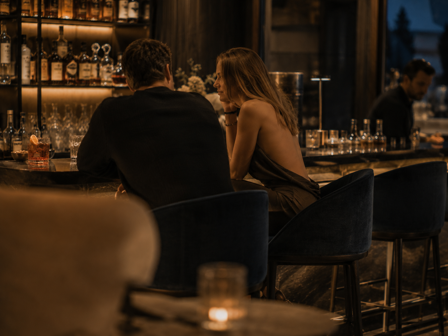 Das Gsieser Tal, ganz nah. Und doch wie ein kleines Geheimnis. Paar sitzt an der stilvoll beleuchteten Bar eines Restaurants