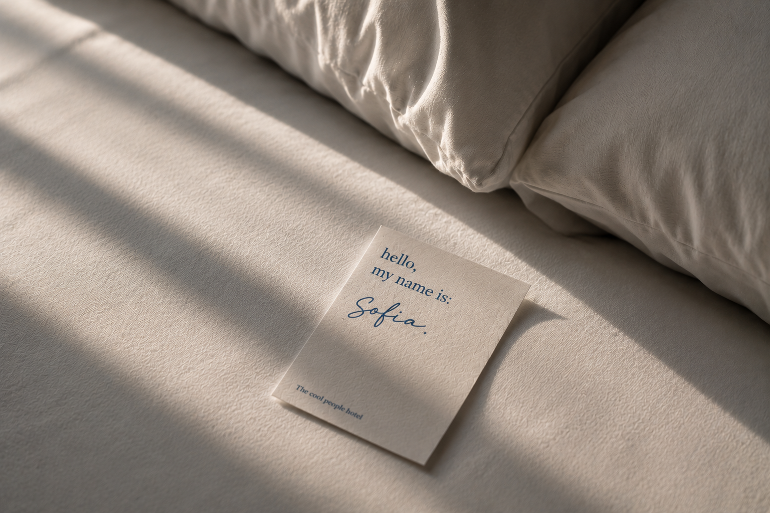 Das Gsieser Tal, ganz nah. Und doch wie ein kleines Geheimnis. Namenskarte mit Sofia auf einem weißen Bett neben Kissen im Sonnenlicht